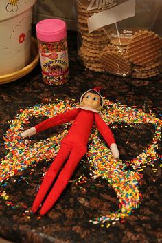 an elf is laying on the counter with sprinkles