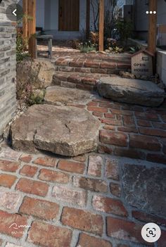 a brick walkway with steps leading up to the front door