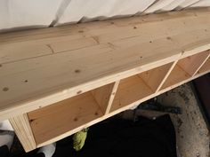 a bed with wooden shelves on top of it and a mattress in the back ground