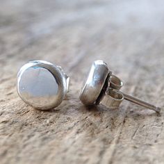 Heres the flat version of my sterling silver pebble earrings. Forged out of solid sterling silver, into these flat pebbles and given a shiny finish. Measuring approximately 1/4 of an inch in diameter, these earrings make quite the statement. Add these to your everyday bohemian look. Also available in a domed pebble shape too. Choose your shape from the drop down menu. {LISTING FEATURES} ~ Boho luxe style ~ Solid sterling silver ~ Flat pebble shape ~ Shiny surface ~ Perfectly imperfect ~... Pebble Jewelry Without Drilling Holes, Minimalist Earrings Studs Pineal Vision Jewelry, Silver Stud Earrings Handmade, Silver Smithing Jewelry Minimalist, Silver Rounded Earrings For Gifting, Silver Rounded Earrings As Gift, Silver Round Earrings As Gift, Silver Round Earrings For Gift, Everyday Minimalist Stamped 925 Earrings