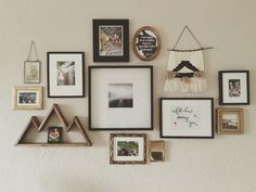 a wall filled with lots of different framed pictures