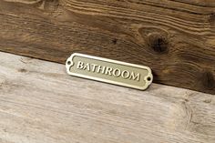 a bathroom sign on the side of a wooden wall