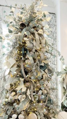 a christmas tree decorated with silver and gold ornaments