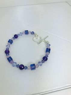 If you love shades of purple, this bracelet is for you. The bracelet made of Amethyst Beads, Swarovski Tanzanite Crystals and Lavender Jade beads is absolutely lovely.  The heart link is the perfect finish.   2 - 6 mm Genuine Faceted Amethyst Round Beads  2 - 6 mm Genuine Smooth Amethyst Round Beads  5 - 6 mm Swarovski Tanzanite Square Beads  6 - 6 mm Tanzanite Bicone Beads  8 - 4 mm Swarovski Tanzanite Bicone Beads 10 - 4 mm Lavender Jade Round Beads    1 - 15 mm Sterling Silver Heart Link Total Length - 7 1/2 inches The bracelet will arrive in a silky zippered jewelry bag (color may vary). Lavender Bracelets With Spacer Beads As Gift, Lavender Bracelets With Spacer Beads For Gift, Purple Beaded Bracelets With Heart Beads For Gifts, Lavender Beaded Crystal Bracelet As A Gift, Blue Amethyst Beaded Bracelets As Gift, Lavender Beaded Crystal Bracelet For Gifts, Purple Crystal Bracelet With Faceted Beads As Gift, Blue Amethyst Beaded Bracelets For Gift, Lavender Faceted Beads Bracelet For Gift