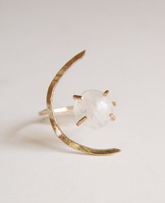 This beautiful white moonstone gemstone features a subtle glow. Set in 14k gold fill, this ring is a perfect for everyday wear or as a statement piece. Featuring a stunning crescent moon shape design. Ring is made in size 6 and is adjustable due to the style of the ring. It can be made larger upon request before purchase. Gemstone is approx. 10mm in diameter. This piece is a very limited edition. Please note: Due to the nature of the moonstones, each of these stones can vary from the original. M Adjustable Ethereal Moonstone Ring, Ethereal Adjustable Moonstone Ring, Adjustable Ethereal White Jewelry, White Moonstone Moon Ring, White Adjustable Celestial Moonstone Ring, Ethereal White Round Moonstone Ring, Celestial Crescent Moonstone Ring, Celestial Moonstone Ring With Moon Charm, Mystical White Moonstone Ring In Moon Shape