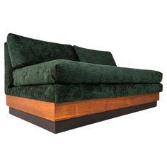 a green couch sitting on top of a wooden table