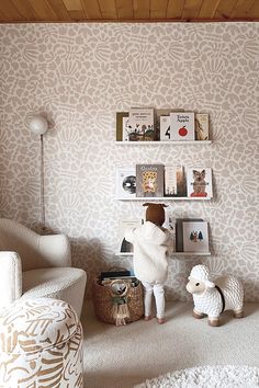 there is a stuffed animal in the corner of this living room with bookshelves and pictures on the wall