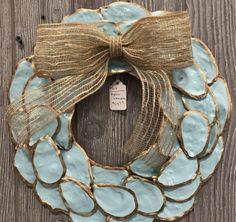 a blue and gold wreath with a bow on it sitting on top of a wooden table