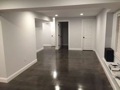 an empty living room with hard wood flooring and white paint on the walls,