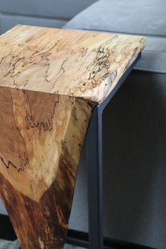 a wooden table sitting on top of a gray couch