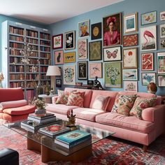 a living room filled with pink couches and lots of pictures on the wall above them