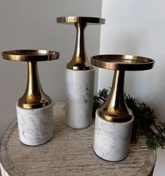 three white marble candlesticks with gold accents