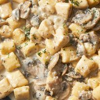 a plate with potatoes, mushrooms and gravy on it