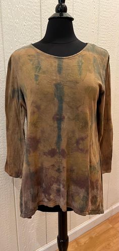 This One of a Kind comfortable tunic tee with asymmetrical hem - longer at both side seams- and 3/4 length sleeves, has a neckline that is comfortably between crew and scoop.  It has had several layers of natural dye (including indigo) as well as very subtle eco-printing (most visible in the second photo).  The garment was folded in different patterns with each dye bath.  The color is more varied in person than the photos suggest.  There is a very subtle geometric (octagon) pattern that was stamped along the hem with a solution used to shift color during the early stages of dyeing. Bohemian Tops With Natural Dye For Fall, Spring Long Sleeve Tops With Natural Dye, Long Sleeve Tops In Natural Dye With Relaxed Fit, Relaxed Fit Long Sleeve Top With Natural Dye, Fall Tunic With Relaxed Fit And Shirttail Hem, Fall Relaxed Fit Tunic With Shirttail Hem, Bohemian Hand Dyed Long Sleeve Tops, Bohemian Hand Dyed Tops For Fall, Casual Long Sleeve Tops With Natural Dye