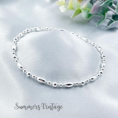 This simple, minimalist beaded anklet, made entirely in .925 sterling silver, makes an elegant and timeless addition to your jewellery collection  The mix of solid sterling silver beads are strung on high quality, strong, professional jewellers' elastic meaning there are no fiddly clasps to deal with, simply roll the anklet over your foot, and onto your ankle  This classic anklet looks stunning as a stand-alone piece or can be worn alongside other anklets to create a more Bohemian style  The ank Silver Elegant Anklets For Everyday Wear, Elegant Silver Anklets For Everyday, Silver Minimalist Anklets For Everyday, Elegant Silver Beaded Bracelet With Oval Beads, Minimalist Hypoallergenic Sterling Silver Anklets, Elegant Silver Anklets With Tiny Beads, Elegant Silver Anklets With Round Beads, Summer Jewellery, Bracelet Summer