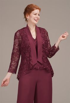 a woman wearing a burgundy colored suit and jacket with lace detailing on the top, smiling