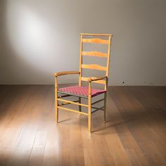 a wooden chair sitting on top of a hard wood floor next to a white wall