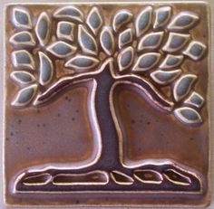 a decorative tile with a tree on it