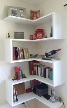 a corner book shelf with books and other items on it