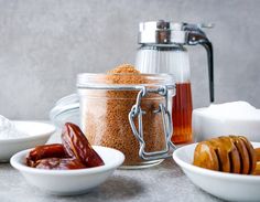 several different types of food in bowls on a table with salt and pepper shakers