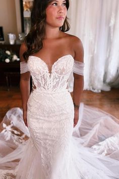 a woman in a wedding dress posing for the camera