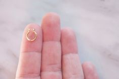 To celebrate 10 years on Etsy, we've open a legacy store featuring all our BEST sellers! Curly Cuffs' smallest septum cuff - The Mini! A septum ring so small it fits on the tip of your finger. The 7mm hoop fits snuggly to your nose for a subtle look and a comfortable fit all day long. NO PIERCING REQUIRED: Try a fake piercing to see what it looks like before getting the real thing OR skip the pain & permanence by simply making Curly Cuffs a permanent part of your look. Faux body piercings allow Tiny Hoop Septum Piercing, Tiny Septum Ring, Small Septum, Nasal Septum, Fake Nose Ring, Faux Piercing, Fake Earrings, Septum Nose, Fake Nose Rings