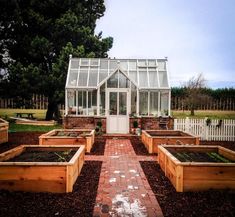 several wooden planters in front of a white house with glass doors and windows on the side