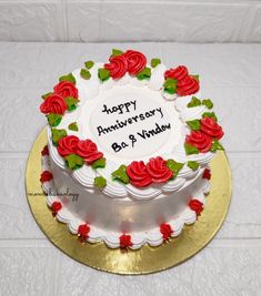 a white and red cake with roses on the top that says happy anniversary bob & window