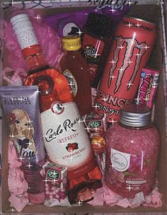 a box filled with lots of different types of food and drinks on top of pink tissue