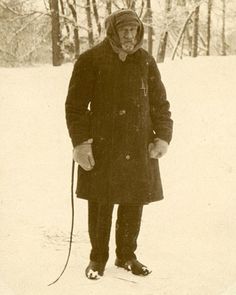 an old man is standing in the snow