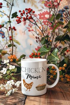 a white coffee mug sitting on top of a wooden table next to flowers and berries