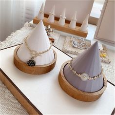 two hats are sitting on top of a table with jewelry in the foreground and other items behind them