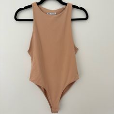 a tan bodysuit hanging on a hanger