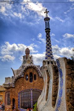 an artistic building with blue and white designs on it's roof, in front of a cloudy sky