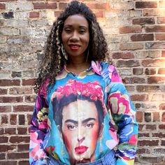 Our Frida in the Garden Button-up Blouse is perfect for channeling your inner Frida Kahlo in style! Light and breezy, this unique top features an artwork of the iconic artist, surrounded by a lively garden of birds - the perfect look for any day you want to feel like spring! Get ready to rock this beautiful blouse and make a bold statement! Product Details Material: Polyester fiberFit: Loose fit (like a shacket) *size small in the photosCare: Machine wash cold, hang to dryShipping: Imported (est Photo Care, Unique Top, Beautiful Blouses, Button Up, Loose Fitting