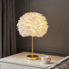 a table with a lamp on top of it and a coffee cup next to it