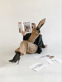 a woman sitting on the floor reading a magazine