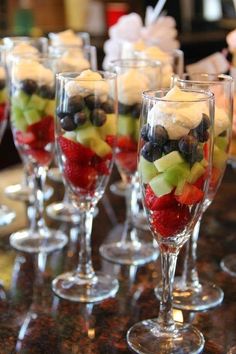 there are many glasses filled with fruit on the table