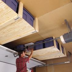 a man is working on the ceiling in his garage