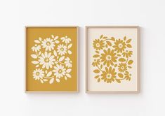 two yellow and white flowers are on the wall next to each other, one is framed in wood