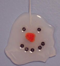 a glass ornament with an orange nose and black eyes on it's side