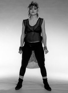 a black and white photo of a woman in tight pants with her hands on her hips