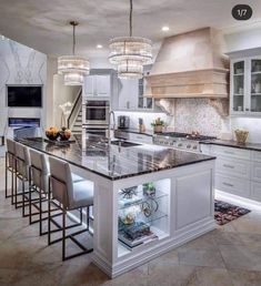 a kitchen with marble counter tops and an island in front of the stove top oven