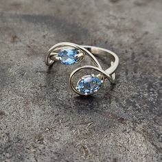 This unique and handmade blue topaz ring is perfect for adding a touch of color and style to your look. With a finger size of 7, this timeless ring is designed to make a statement. It is one of a kind, perfect for those who appreciate craftsmanship and all things special. Topaz Open Ring, Formal Turquoise Rings With Blue Topaz, Blue Gemstone Rings With White Topaz, Blue White Topaz Ring With Gemstone, Modern Blue Topaz Birthstone Ring For Promise, Modern Blue Topaz Birthstone Promise Ring, Blue Topaz Rings With Polished Finish For Anniversary, Blue Topaz Gemstone Ring, Unique Blue Topaz Ring For Anniversary