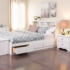 a bedroom with white furniture and wood floors