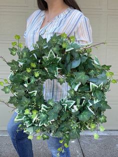 a woman holding a wreath made out of leaves