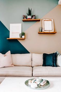 a living room filled with furniture and decor on top of a white coffee table in front of a blue wall