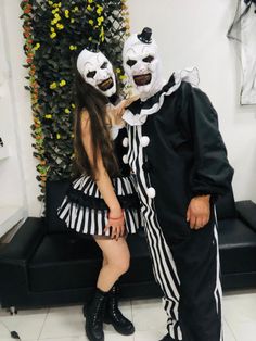 two people dressed in costumes standing next to each other with their faces painted black and white