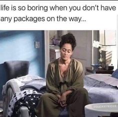 a woman sitting on top of a bed next to a pile of boxes and bags