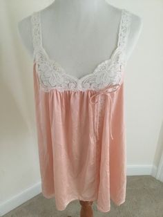 Vintage Peach nylon baby doll top by Val Mode.  Tagged a size small Simple tie closure and open from there down to hem.  Ivory lace.  Not strap lace at front on one side is coming loose and needs a few stitches to reattach!  See photos.  Very adorable! Bust is 17 inches 10 inch straps are not adjustable 28 inches long Vintage condition.  Tag is worn.  Final sale. Pink Delicate Lace Sleepwear For Spring, Pink Delicate Lace Sleepwear For Summer, Sheer Pink Lace Top, Pink Lace Camisole In Coquette Style, Pink Lace Coquette Camisole, Pink Lace Camisole For Sleep, Pink Sleeveless Lace Top With Lace Trim, Sleeveless Pink Lace Top With Lace Trim, Pink Lace Sleep Camisole